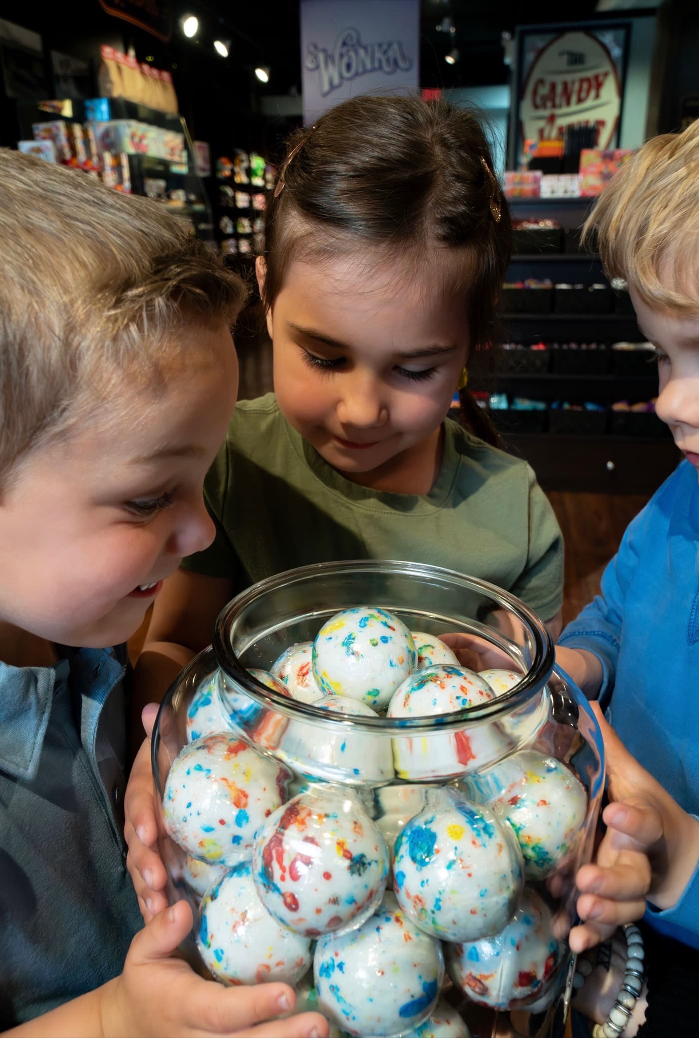 Kids peering into a jar of giant jawbreakers
